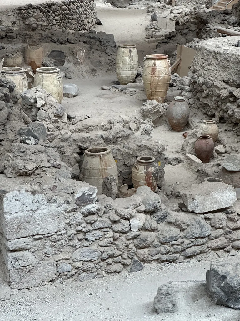 Ancient terracotta amphorae and storage jars among stone ruins